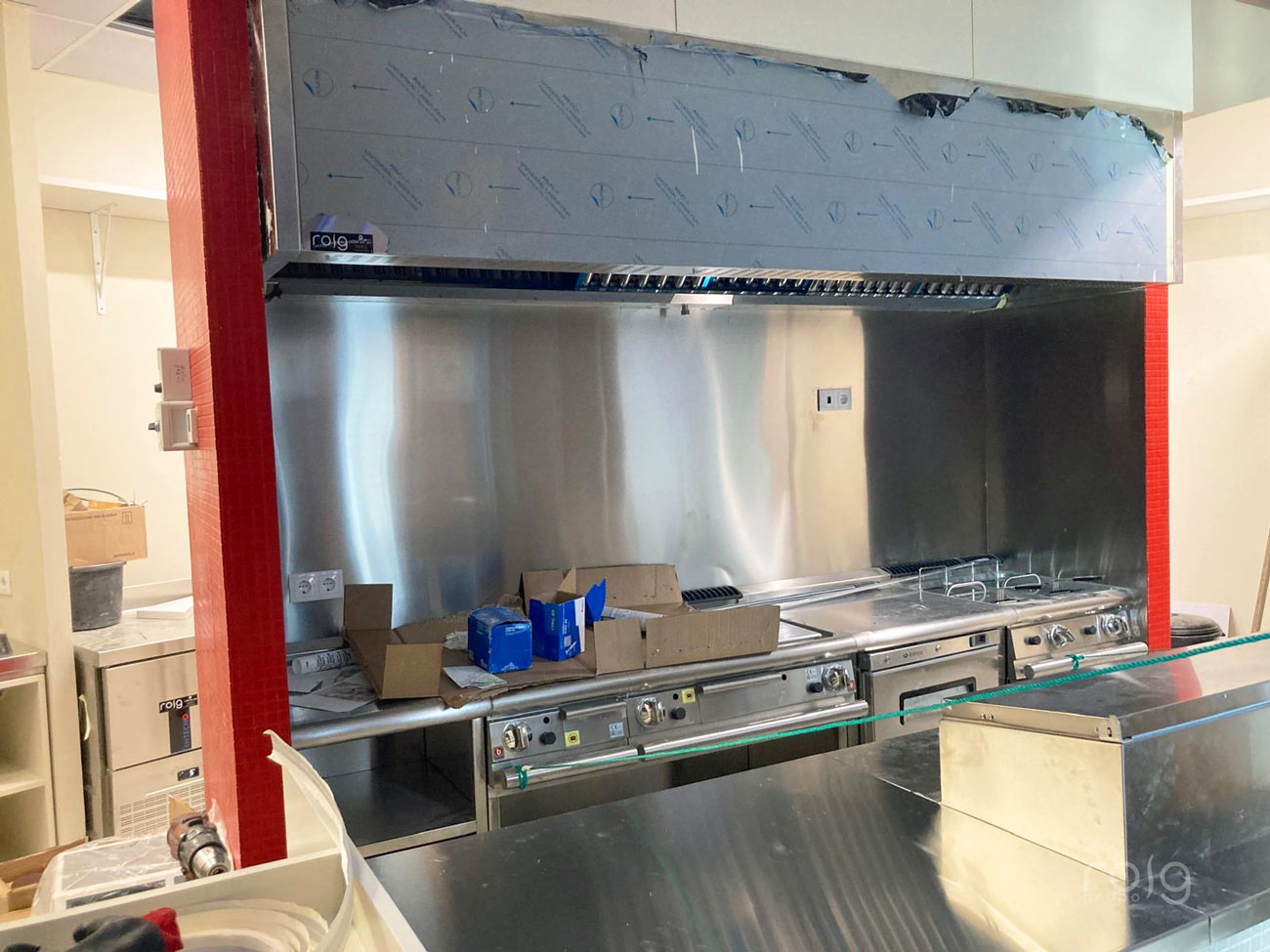 Vista del tren de cocci&oacute;n con plancha y fuegos bajo campana extractora roig durante el montaje de la cocina profesional de PPANG en A Coru&ntilde;a